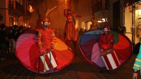 Rainbow parade on stilts by colorful stilt walkers