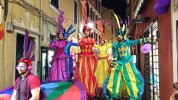 Rainbow parade on stilts by colorful stilt walkers