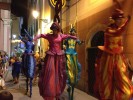 Rainbow parade on stilts by colorful stilt walkers